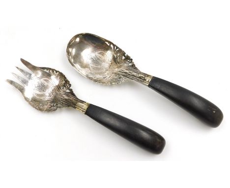 A Malaysian serving fork and spoon set, white metal, chased and pierced with stylised flowers and dragons, with curved horn h