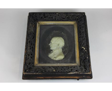 A wax profile portrait of a 19th century gentleman in carved wood frame, 34cm by 39cm