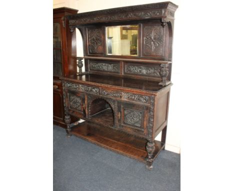 A W Whiteley, London, dark oak dresser with rectangular bevelled mirror back above one shelf, on carved border base with two 