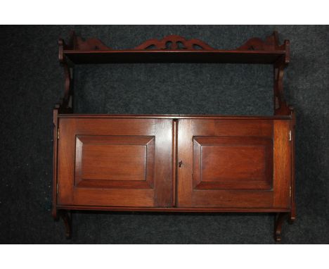 A mahogany wall unit, one shelf above two panel doors enclosing a cupboard with one shelf 62cm  