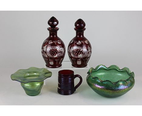 A pair of Bohemian ruby glass cut glass decanters, together with pearlescent green dish and vase and a stained red glass mug