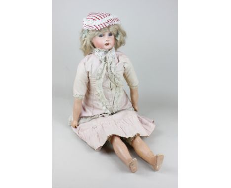 A French Lanternier bisque porcelain head doll with blonde hair, blue glass eyes, open mouth and composite limbs, in pink cot