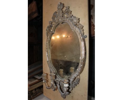 A giltwood and gesso oval girondelle wall mirror with shell surmount and three light candle holders (a/f), 94cm high, (NC)