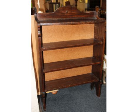 A dark oak bookcase of four shelves, the top shelf bowed with beaded design, 73cm