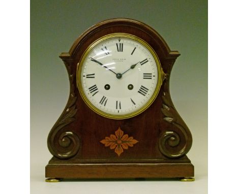 Late 19th/early 20th Century inlaid and carved mahogany cased mantel clock, the white enamel dial with Roman numerals and ret