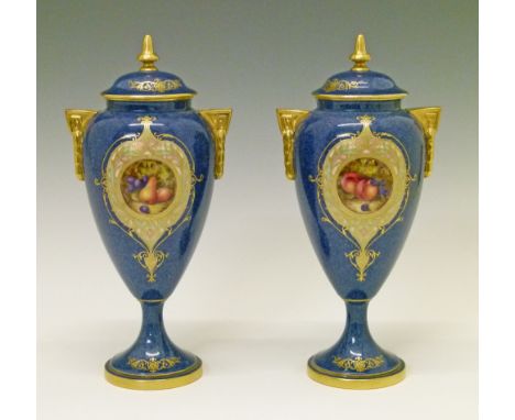 Pair of Royal Worcester urn shaped vases and covers by William Bee, each having a circular reserve panel painted with fruit, 