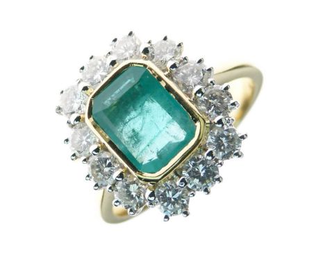 Emerald and diamond cluster ring, the step cut stone measuring approximately 8mm x 6mm x 2.7mm deep, enclosed by twelve brill