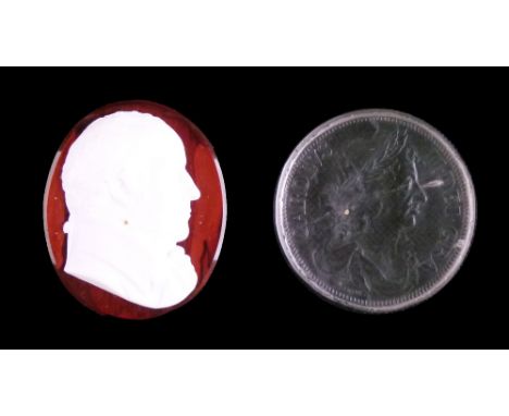 19th Century glass paste portrait medallion depicting a gentleman in profile on a mottled red ground, 4.5cm high together wit