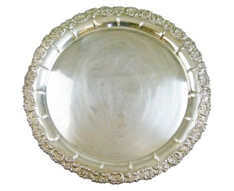 George V silver salver having a foliate border and standing on four scroll feet, engraved presentation inscription 'Given to 