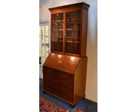 A George III style mahogany inlaid bureau bookcase, circa early 20th century, with two glazed astragal doors, enclosing shelv