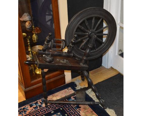 A vintage spinning wheel, raised on tripod legs, 85cm high x 81cm wide