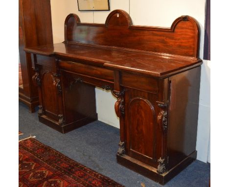 A Victorian mahogany pedestal sideboard, with arched pediment above breakfront top and single drawer, flanked with a panelled