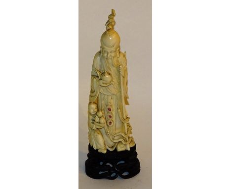 A Japanese carved ivory figure of an Oni with child, circa late 19th/early 20th century, with red character marks to his belt