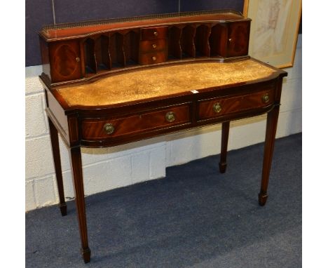 A reproduction Carlton House style mahogany desk, with metal gallery rail above fitted drawers and pigeon holes, with tooled 