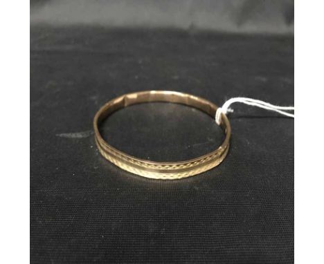 NINE CARAT GOLD BANGLE with engraved decoration