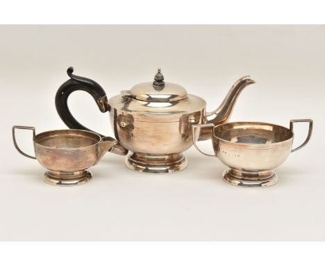 AN EARLY 20TH CENTURY SILVER THREE PIECE TEA SET, comprising of a small teapot fitted with an ebonised handle, together with 