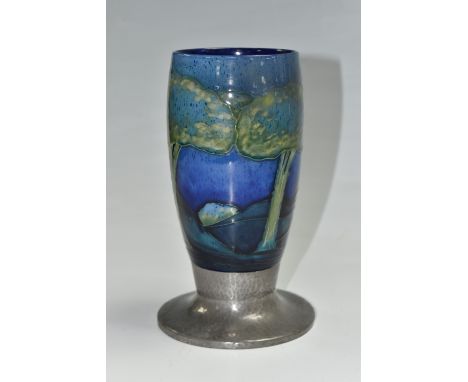 A 1920'S MOORCROFT FOR LIBERTY &amp; CO 'MOONLIT' VASE WITH A TUDRIC BASE tube lined on a blue ground, mounted on a hand hamm
