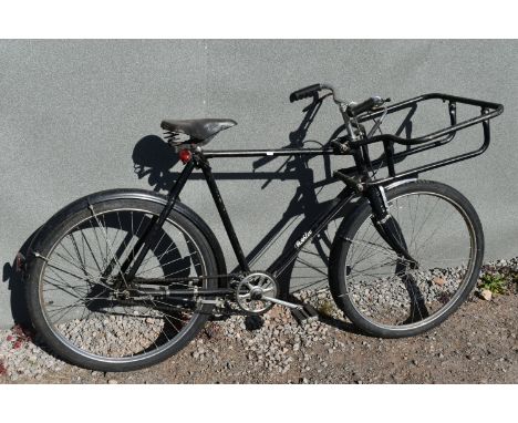 A PASHLEY BAKERS DELIVERY BIKE, in black, 23   frame, with a three speed stuntmen gears, front basket, sprung leather saddle,
