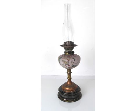 A Victorian glass, brass and copper oil lamp by Sherwoods of Birmingham - the pink opaque glass reservoir with enamelled flor