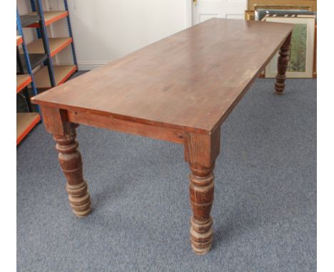 A large, heavy stained pine refectory table - second half 20th century, the rectangular top raised on substantial turned supp