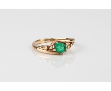 A 14ct gold and emerald single stone twist ring - unmarked, tests as 14ct gold, the oval cut emerald, approx. 5.75 x 4.5mm, i