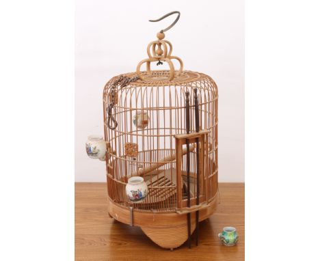 A Chinese bamboo bird cage - mid-20th century, the cylindrical cage with domed top, on bracket feet, with five porcelain bird