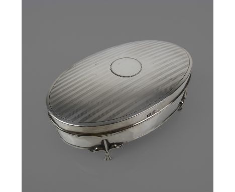 An oval silver jewel-casket with engine-turned top standing on three-toed feet: hallmarked Birmingham 1912 by&nbsp;Cornelious