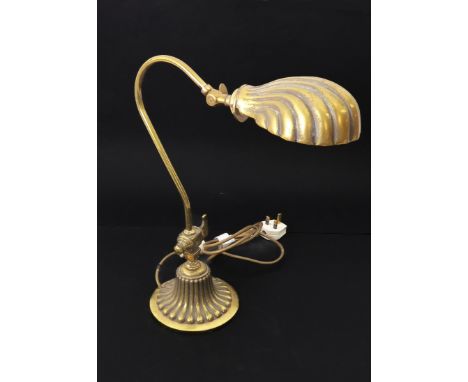 A Victorian style brass desk or reading lamp - with cast shell-shaped swivel-head shade and scroll arm, rising from a cast br