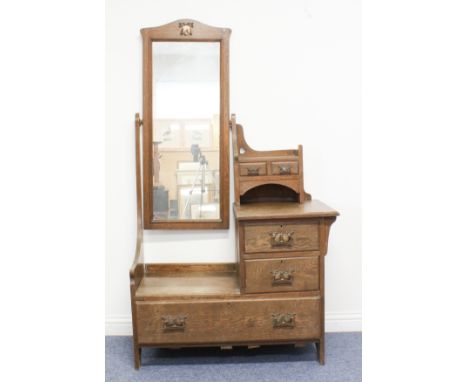 An oak Arts &amp; Crafts style dressing-table in the manner of Liberty - the tall, arched mirror with stylised floral copper 