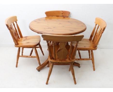 A circular pine kitchen table and four chairs - in&nbsp;19th century style, the moulded top on a turned column to three reede