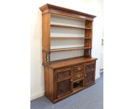 A late 19th century Continental stained pine dresser - the flared, ogee moulded cornice over an open three-shelf plate rack, 