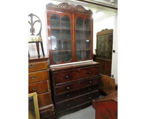A Regency mahogany bookcase with a carved cornice over a pair of glazed panelled doors above a secret air drawer and three gr