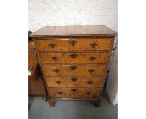 An early 20th century Queen Anne inspired walnut dressing chest with a crossbanded top over five graduated long drawers with 