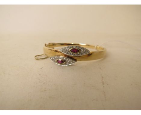 A 14ct gold bangle set with white stones surrounding two red stones, 16.8 grams