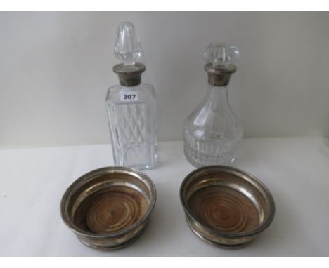 Two silver collared cut glass decanters, together with a pair of silver wine coasters