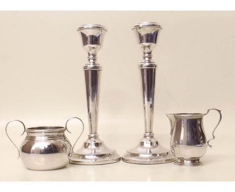 Pair of filled silver candlesticks and a silver cream jug and sugar basin Condition report: see terms and conditions