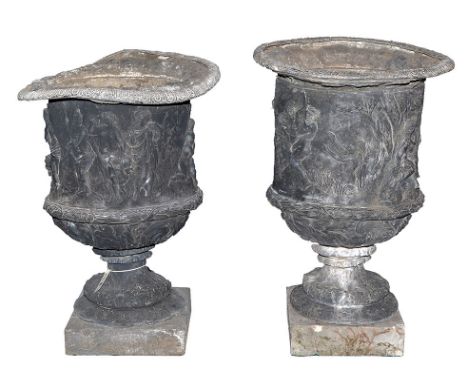 A pair of 19th Century cast lead garden urns, each decorated with a frieze of classical figures above wreath and floral decor