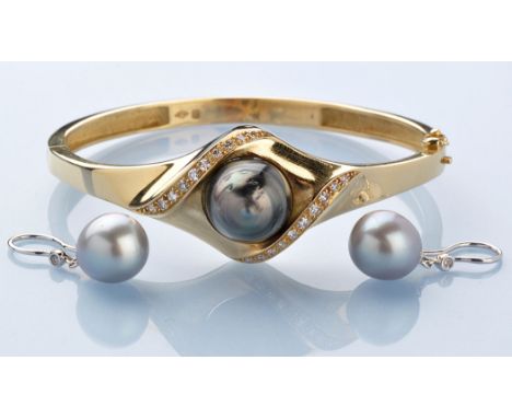 A cultured black pearl and diamond set 18ct. yellow gold bangle, the central black pearl within a shaped mount set twenty gra