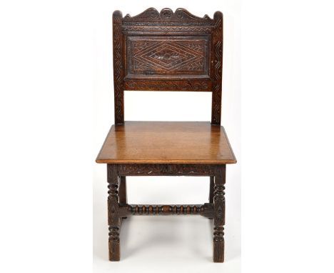 An 18th Century and later carved oak hall chair, the swan neck cresting rail above carved back panel, later seat above carved