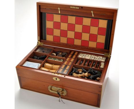 An early 20th Century games compendium, the mahogany box with lacquered brass cartouche and stringing, opening to reveal ches