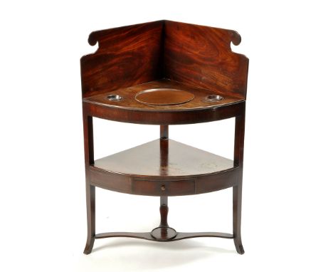 A George III mahogany bowfront corner washstand, the splash back with shaped scrolling corners, cut-out basin stand and two s