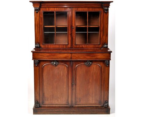 A Victorian mahogany bookcase, the flared cornice above a pair of glazed panelled doors enclosing shelves, two frieze drawers