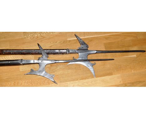 Two 16th Century style German halberds, each with long needle point, parrying hook, concave axe head and hardwood shaft, one 