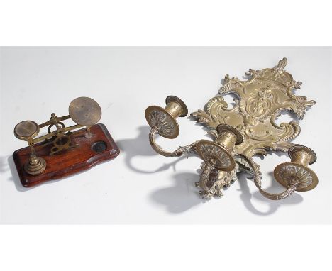 A set of brass scales on a wooden base together with a brass three candle sconce, (2)