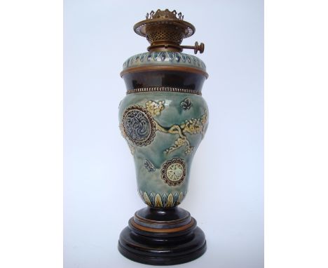 A Doulton Lambeth glazed stoneware oil lamp decorated by Harriet E Hibbut, of inverted baluster form, decorated in raised rel