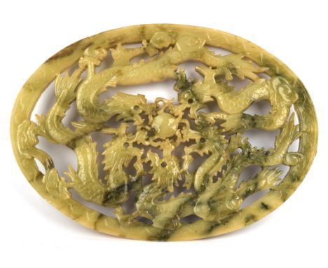 A Chinese, Mottled Green, Hardstone Carving; the reticulated design with dragons surrounding a flaming pearl; 34 cm diameter,