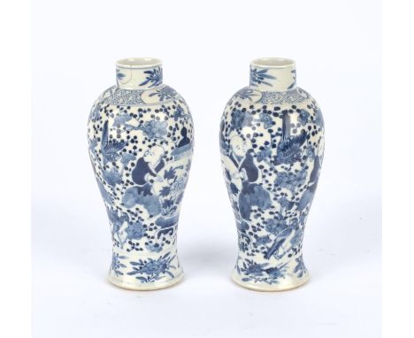 A pair of blue and white vases, 22cm high, each one with a Kangxi four-character mark, but not of the period; together with a