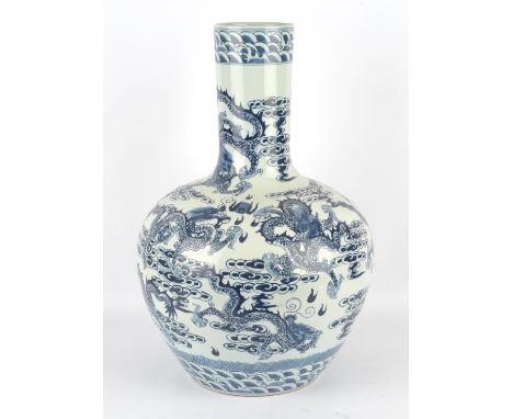A modern Chinese blue and white porcelain vase of large proportions decorated with a dragon chasing a flaming pearl amongst s