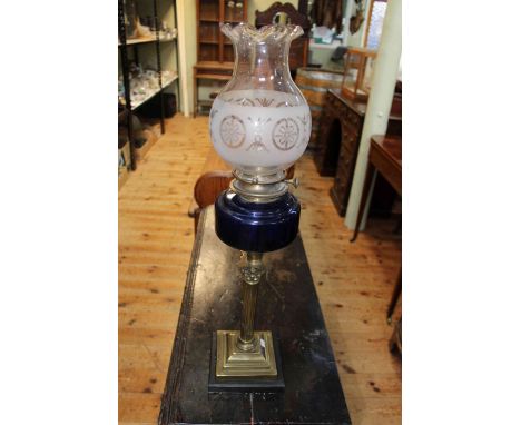 Victorian brass oil lamp with dark blue glass reservoir, 67cm high.