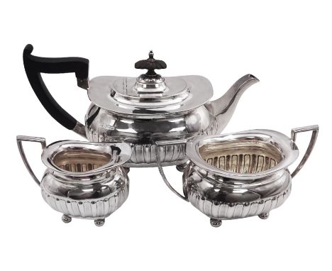 Early 20th century silver three piece tea service, comprising teapot, twin handled sucrier, and milk jug, each of oval part f